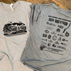 Hike-A-Thon t-shirts front and back, Bella+Canvas shirt to the left showing the front and Sport-Tek shirt to the right showing the back. Comparison shows color difference.