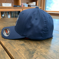 Navy blue cap with a brand logo on a wooden surface