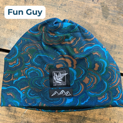 Blue beanie with an organic, rounded geometric pattern in lighter blues and orange, with a black and white LGLC logo embroidered tag on a wooden surface, featuring the style name 'Fun Guy'.