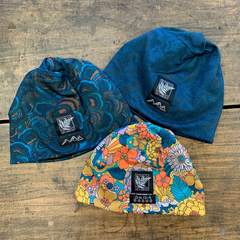 Three beanies with different patterns on a wooden surface