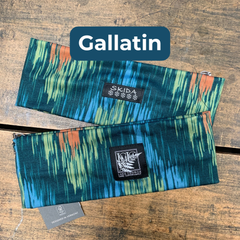 Two patterned rectangles with visible brand labels on a wooden surface, featuring the brand 'Gallatin'. 