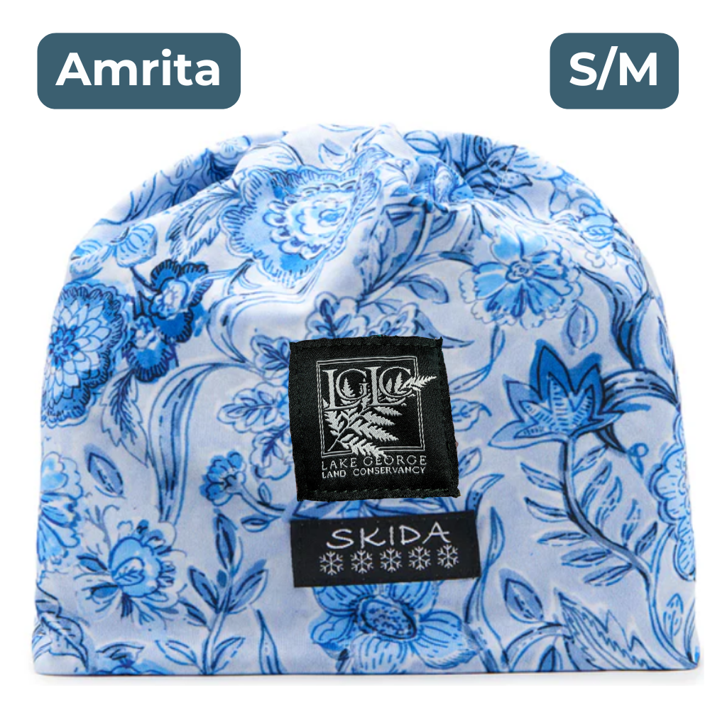 White beanie with a vintage blue floral pattern, with black and white embroidered labels featuring the LGLC logo and Skida logo. "Amrita"