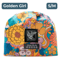 Bold, colorful beanie with a 70's style floral pattern, with black and white embroidered labels featuring the LGLC logo and Skida logo. "Golden Girl"