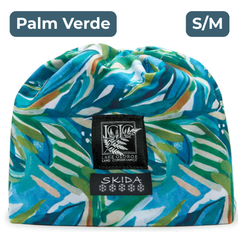 White beanie covered with a tropical leafy green and blue pattern, with black and white embroidered labels featuring the LGLC logo and Skida logo. "Palm Verde"